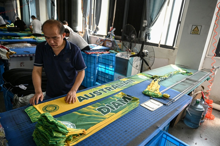 Un employé repasse des écharpes dans une usine qui produit des chapeaux et des écharpes à Yiwu, dans la province du Zhejiang, dans l'est de la Chine, le 18 septembre 2025
