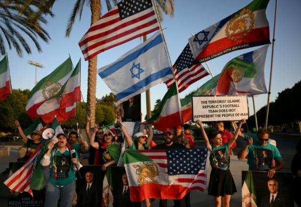 Des manifestants agitent des drapeaux de l'Iran pré-révolutionnaire à l'extérieur du stade où s'entraîne la sélection iranienne, le 14 juin 2026 à Los Angeles, à la veille de son entrée en lice dans le Mondial contre la Nouvelle-Zélande