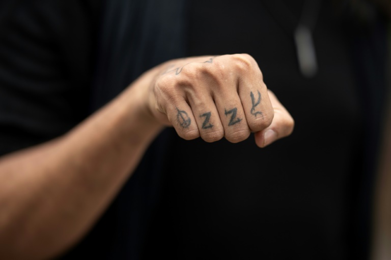 Un fan avec un tatouage d'Ozzy Osbourne sur les phalanges arrive au concert
