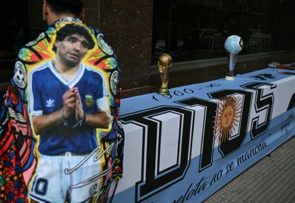 Un fan enveloppé dans une banderole à l'effigie de Diego Maradona, devant le tribunal de San Isidro, lors de la dernière audience consacrée aux plaidoiries de la défense dans le procès concernant son décès, le 21 octobre 2026 dans la province de Buenos Aires, en Argentine