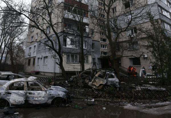 Des employés municipaux ukrainiens nettoient une rue de Dnipro dans la région centrale de Dnipropetrovsk après une frappe de drones russes le 7 janvier 2026 