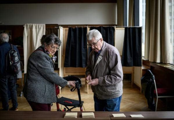 Des habitants votent pour le second tour des municipales, le 22 mars 2026 à Lyon