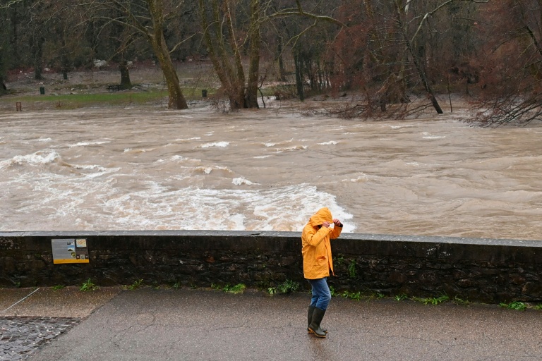 Un passant sur les berges de l'Hérault, qui a débordé suite aux fortes pluies à Laroque, le 22 décembre 2025