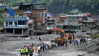 Des pelleteuses dégagent la boue et les décombres après la crue destructrice qui a fait au moins 633 morts à la frontière entre le Népal et la Chine, le 29 août 2026 à Dhunge Bazaar, dans le district népalais de Nuwakot  