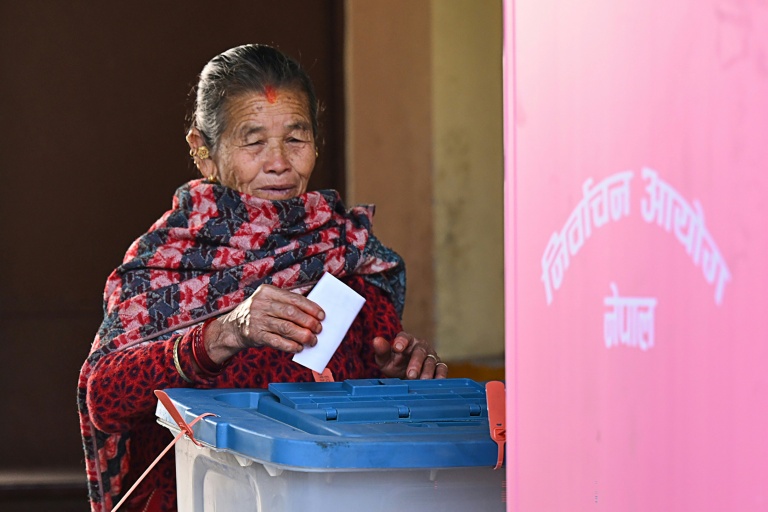 Une femme dépose son bulletin dans l'urne dans un bureau de vote lors des élections législatives népalaises à Katmandou, le 5 mars 2026