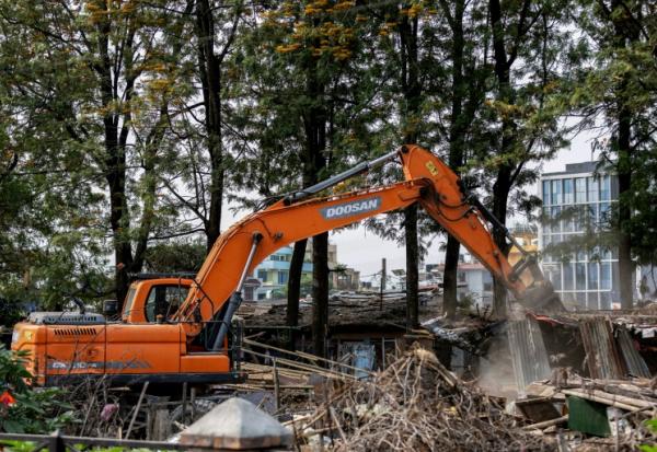 Une pelleteuse entame la démolition des bidonvilles abritant des milliers de personnes le long des berges de la capitale népalaise Katmandou, le 25 avril 2026