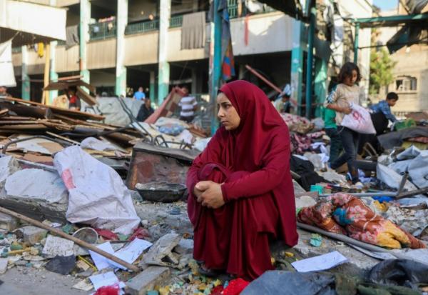 Une femme est assise au milieu des décombres après le bombardement d'une école à Gaza-ville, le 26 mai 2025