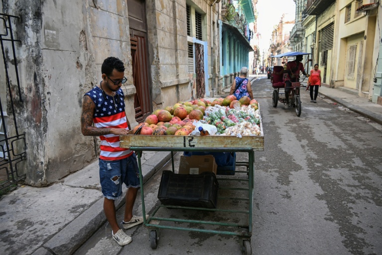 Un vendeur de rue avec un t-shirt à l'effigie du drapeau américain dans une rue de La Havane, le 18 mai 2026