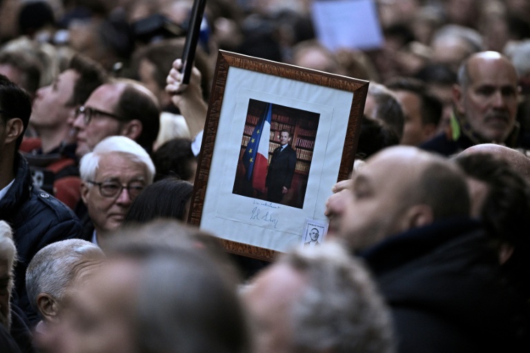 Des partisans de l'ancien président Nicolas Sarkozy rassemblés devant sa résidence avant son départ pour la prison de La Santé, le 21 octobre 2025 à Paris