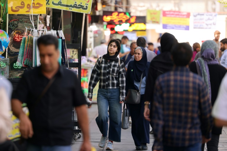 Des passants dans une rue animée de Téhéran, le 28 septembre 2025 en Iran