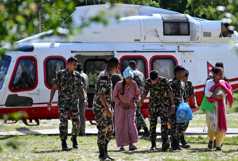 Des militaires soutiennent une rescapée, au camp de Trishuli, dans le district de Nuwakot au Népal, le 28 août 2026