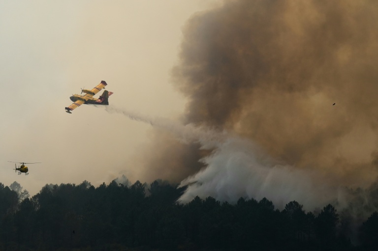 Vue prise depuis un hélicoptère de la Sécurité civile montrant un Canadair larguant de l'eau sur un incendie à Saint-Jean-d'Illac, en Gironde, le 28 juillet 2026