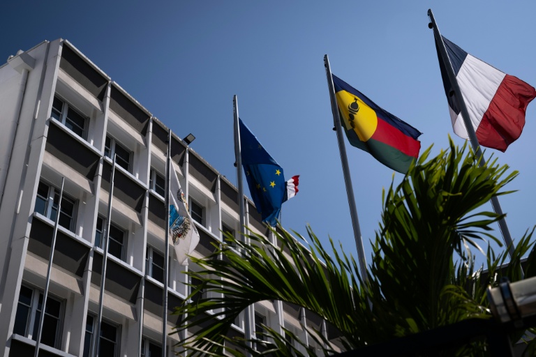 Un drapeau kanak (2e d), le drapeau français (d) et le drapeau européen (2eg) devant l'hôtel de ville de Nouméa, en Nouvelle-Calédonie, le 23 septembre 2024