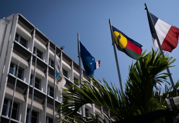 Un drapeau kanak (2e d), le drapeau français (d) et le drapeau européen (2eg) devant l'hôtel de ville de Nouméa, en Nouvelle-Calédonie, le 23 septembre 2024