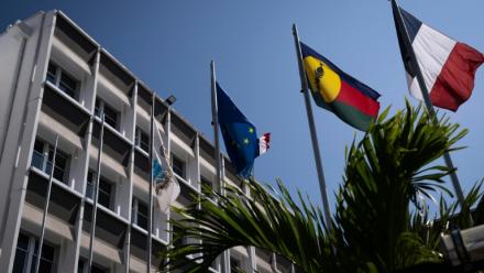 Un drapeau kanak (2e d), le drapeau français (d) et le drapeau européen (2eg) devant l'hôtel de ville de Nouméa, en Nouvelle-Calédonie, le 23 septembre 2024