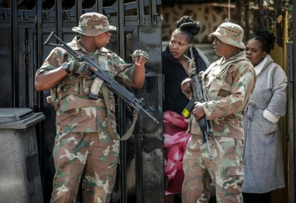 Des militaires de la Force de défense nationale d'Afrique du Sud (SANDF) près des lieux de la fusillade dans un bar de l'ouest de Johannesburg qui a fait 17 morts et 15 blessés, le 27 septembre 2026  