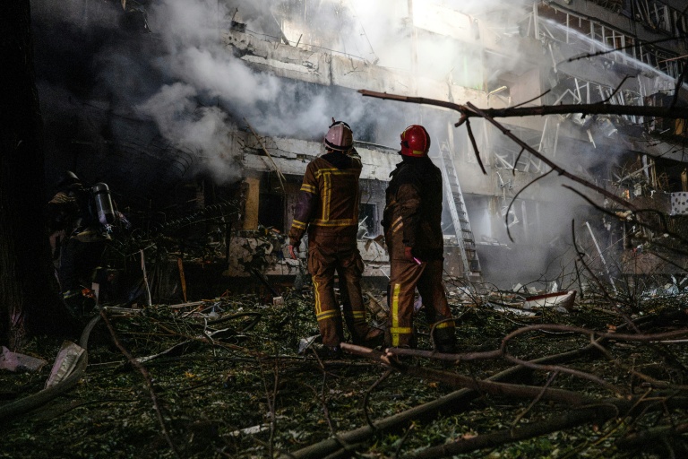 Des pompiers sur le site d'une frappe de missile russe contre un immeuble résidentiel à Kiev, le 14 octobre 2026 en Ukraine