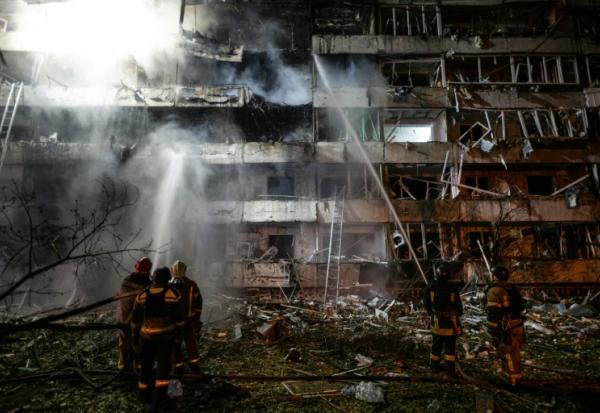 Des pompiers sur le site d'une frappe de missile russe contre un immeuble résidentiel à Kiev, le 14 octobre 2026 en Ukraine