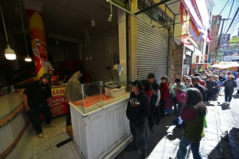 Des habitants font la queue pour acheter du poulet sur un marché touché par les pénuries dues aux barrages routiers et aux manifestations contre le président Rodrigo Paz, le 19 mai 2026 à La Paz, en Bolivie
