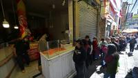 Des habitants font la queue pour acheter du poulet sur un marché touché par les pénuries dues aux barrages routiers et aux manifestations contre le président Rodrigo Paz, le 19 mai 2026 à La Paz, en Bolivie