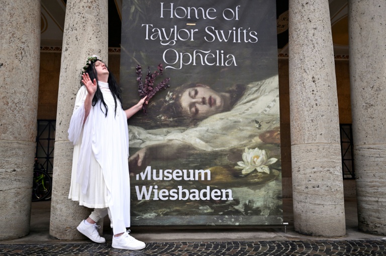 Une fan de Taylor Swift pose devant une affiche 