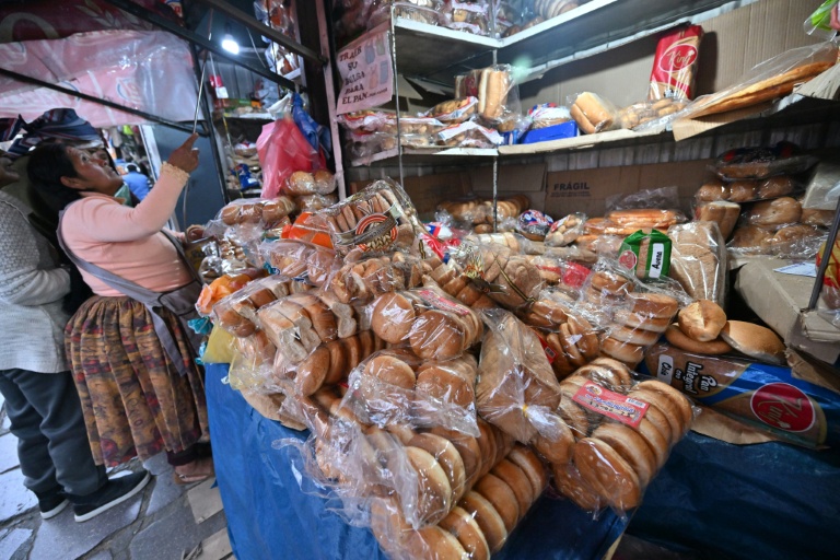 Une femme achète du pain sous sachet sur un marché à La Paz, en Bolivie, le 31 juillet 2025