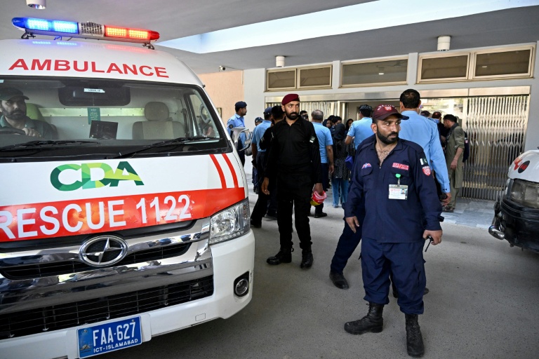 Des agents de sécurité se tiennent près d'une ambulance après un incendie à l'hôpital PIMS, à Islamabad, qui a coûté la vie à 14 nourrissons, le 26 août 2026.