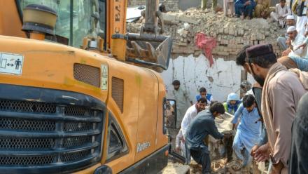 Des personnes transportent le corps d'une victime après un attentat contre un poste de contrôle de police à Bannu, dans le nord-ouest du Pakistan, le 10 mai 2026