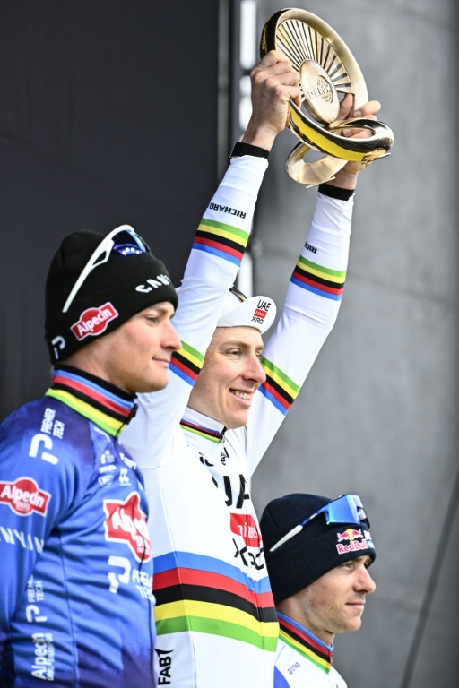 Le coureur slovène de l'équipe UAE, Tadej Pogacar (au centre), célèbre sa victoire au Tour des Flandres 2026, entouré sur le podium du Néerlandais Mathieu van der Poel (à gauche), de l'équipe Alpecin, deuxième, et du Belge Remco Evenepoel (à droite), de l'équipe Red Bull, troisième, à Haaltert, le 5 avril 2026