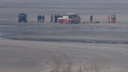 Des véhicules de secours et des unités médicales sur la plage pour soigner des migrants après qu'une tentative de traversée illégale de la Manche a tourné au drame, le 9 avril 2026 à Equihen-Plage, dans le Pas-de-Calais