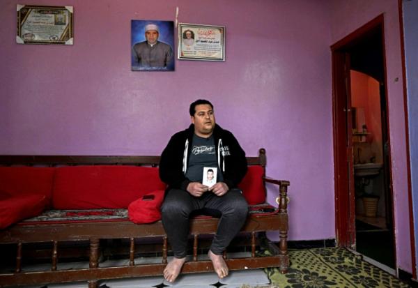 Youssef Ibrahim montre un portrait de son frère Hamdy Ibrahim, 18 ans, disparu en Méditerranée, lors d'une interview dans le village d'Abdallah Aziza, en Egypte, le 21 janvier 2026