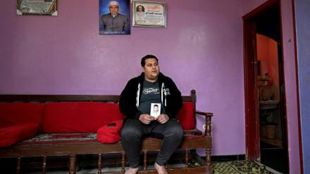 Youssef Ibrahim montre un portrait de son frère Hamdy Ibrahim, 18 ans, disparu en Méditerranée, lors d'une interview dans le village d'Abdallah Aziza, en Egypte, le 21 janvier 2026