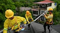 Des ouvriers installent des panneaux solaires sur un toit à Carmona, aux Philippines, le 9 juillet 2026