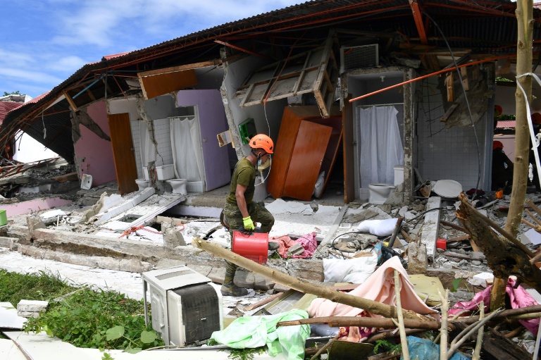 Un sauveteur arrive devant un  bâtiment effondré où la disparition de trois personnes a été signalée après un séisme, dans la ville de Bogo, aux Philippines, le 1er octobre 2025