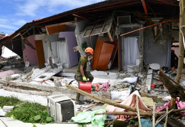 Un sauveteur arrive devant un  bâtiment effondré où la disparition de trois personnes a été signalée après un séisme, dans la ville de Bogo, aux Philippines, le 1er octobre 2025