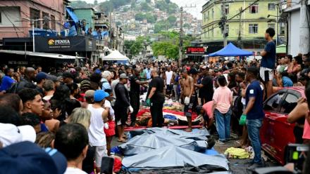 Des habitants se tiennent devant des corps alignés  dans une des favelas du Complexo da Penha, à Rio de Janeiro, le 29 octobre 2025