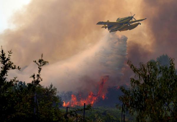 Un avion bombardier d'eau Air Tractor AT-802F procède à un largage sur un incendie de forêt près de San Martin de Valdeiglesias, à environ 70km à l'ouest de Madrid, le 26 juillet 2026 