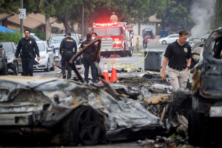 Des policiers et enquêteurs sur le site où s'est écrasé un avion privé, dans un quartier résidentiel de San Diego, en Californie, le 22 mai 2025