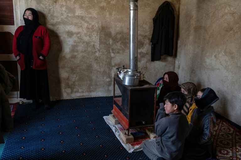Arefa Ibrahimi (à gauche), une Afghane revenue d'Iran, répond devant ses enfants aux questions de l'AFP dans sa maison nouvellement construite à Jar-e-Khushk, dans la banlieue de la province de Bamiyan, le 19 janvier 2026
