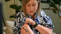 Mia Bannister, la mère d'Ollie Hughes, décédé à l'âge de 14 ans, montre sur son bras un tatouage dédié à son fils lors d'une interview à Sydney, le 7 novembre 2025 en Australie