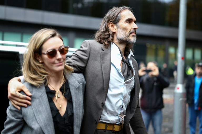 Le comédien britannique Russell Brand, accompagné de son épouse Laura Gallacher, arrive au tribunal de Southwark pour son procès pour viols et agressions sexuelles, le 27 octobre 2026 à Londres
