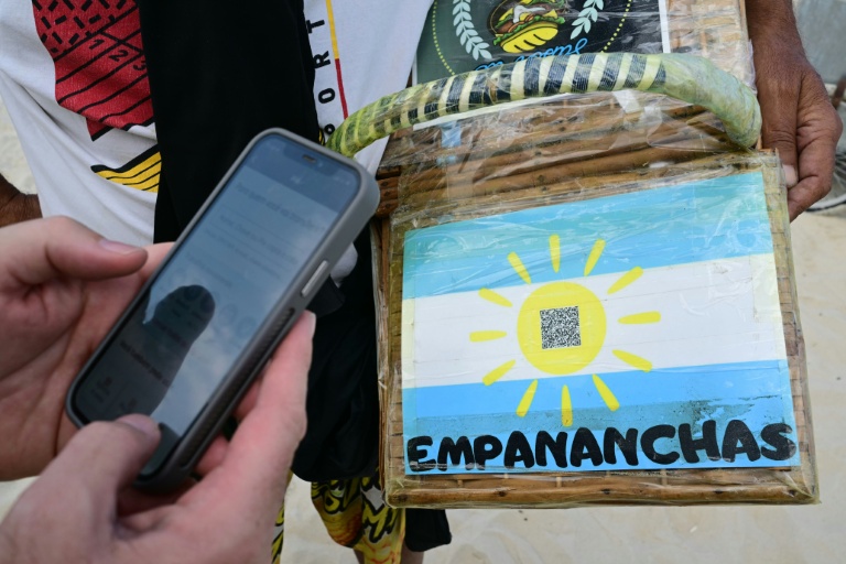 Un homme règle un achat sur la plage de Copacabana à l'aide du système de paiement instantané brésilien PIX, à Rio de Janeiro, le 9 juillet 2026 au Brésil