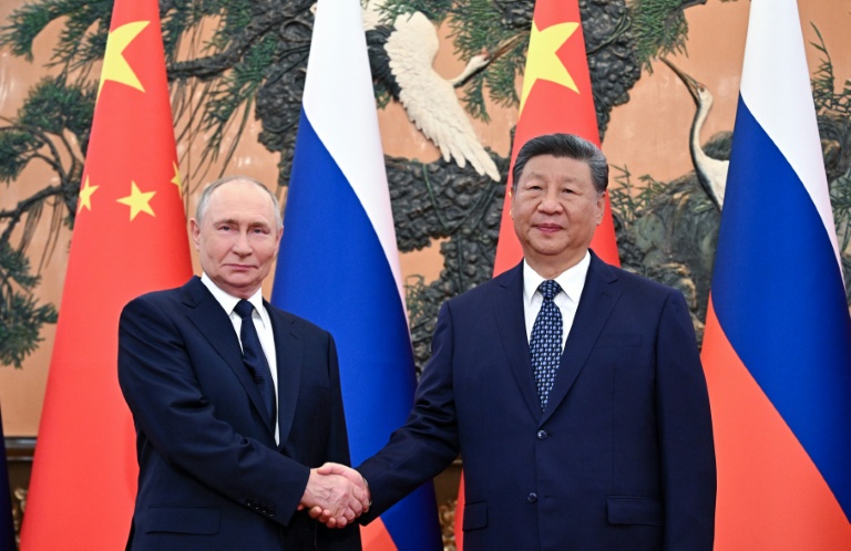Photo diffusée par l'agence de presse russe Sputnik montrant le président russe Vladimir Poutine (g) et le président chinois Xi Jinping lors d'une rencontre au Palais de l'Assemblée du Peuple à Pékin, le 2 septembre 2025