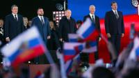 Le président russe Vladimir Poutine (au centre) chante l'hymne national lors d'un meeting marquant l'annexion à la Russie des régions ukrainiennes de Lougansk, Donetsk, Kherson et Zaporijjia, sur la place rouge à Moscou, le 30 septembre 2022