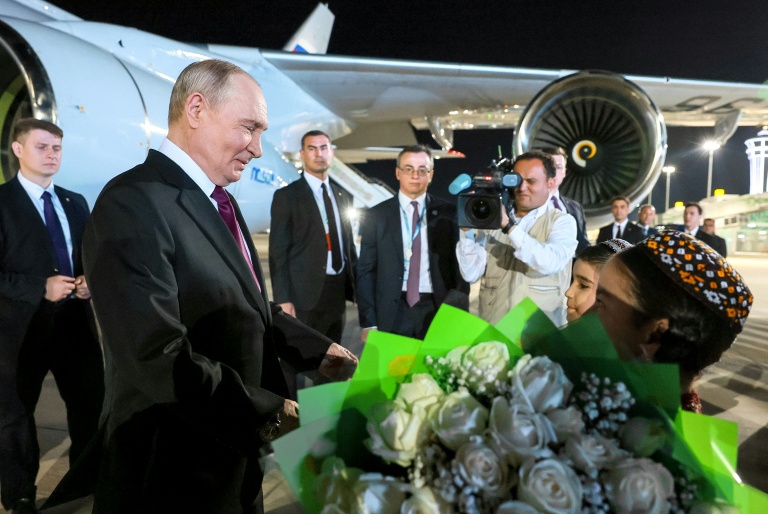 Des enfants accueillent le président russe Vladimir Poutine à sa descente d'avion, le 8 octobre 2026 à Turkmenbashi au Turkménistan