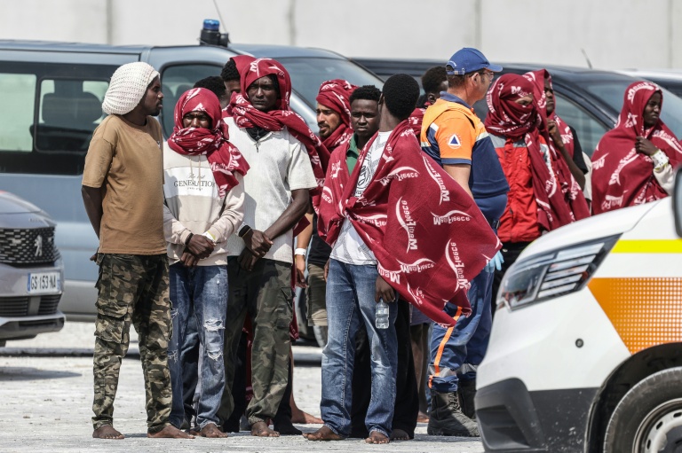 Des migrants attendent après avoir débarqué d'un navire, après leur sauvetage en mer alors que leur embarcation avait pris feu lors d'une tentative de traversée de la Manche, au port de commerce de Boulogne-sur-Mer, le 4 août 2026