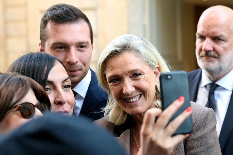La présidente du groupe RN à l'Assemblée nationale Marine Le Pen pose pour un selfie dans la cour de l'Hôtel Matignon à Paris le 17 septembre 2025
