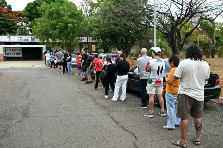 Des électeurs attendent l'ouverture des bureaux pour le premier tour de la présidentielle au Brésil à Cidade Estrutural, en périphérie de Brasilia, le 4 octobre 2026 
