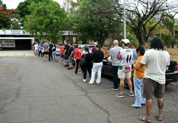 Des électeurs attendent l'ouverture des bureaux pour le premier tour de la présidentielle au Brésil à Cidade Estrutural, en périphérie de Brasilia, le 4 octobre 2026 