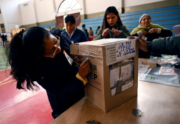 Une assesseure ouvre une urne alors qu'elle se prépare à compter les votes après la fermeture d'un bureau lors de l'élection présidentielle, à La Paz le 17 août 2025.